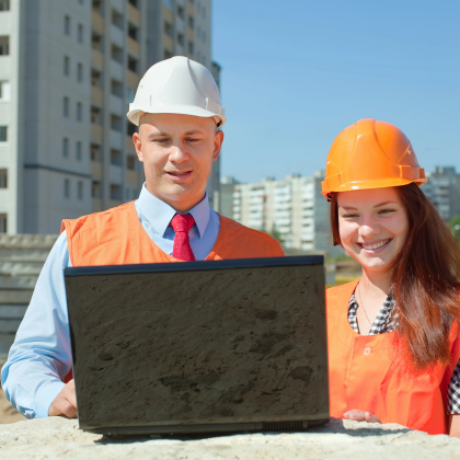 Construction team reviewing ADU project on laptop at job site – Best ADU LA