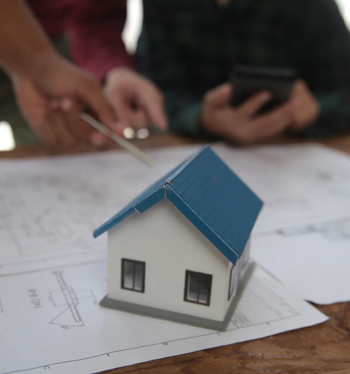 Architectural ADU plans Los Angeles CA small house model over construction drawings showing layout design and drafting work