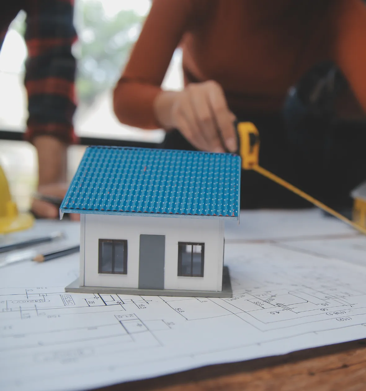 ADU plans architectural design Los Angeles CA house model on blueprints with measuring tools and planning process